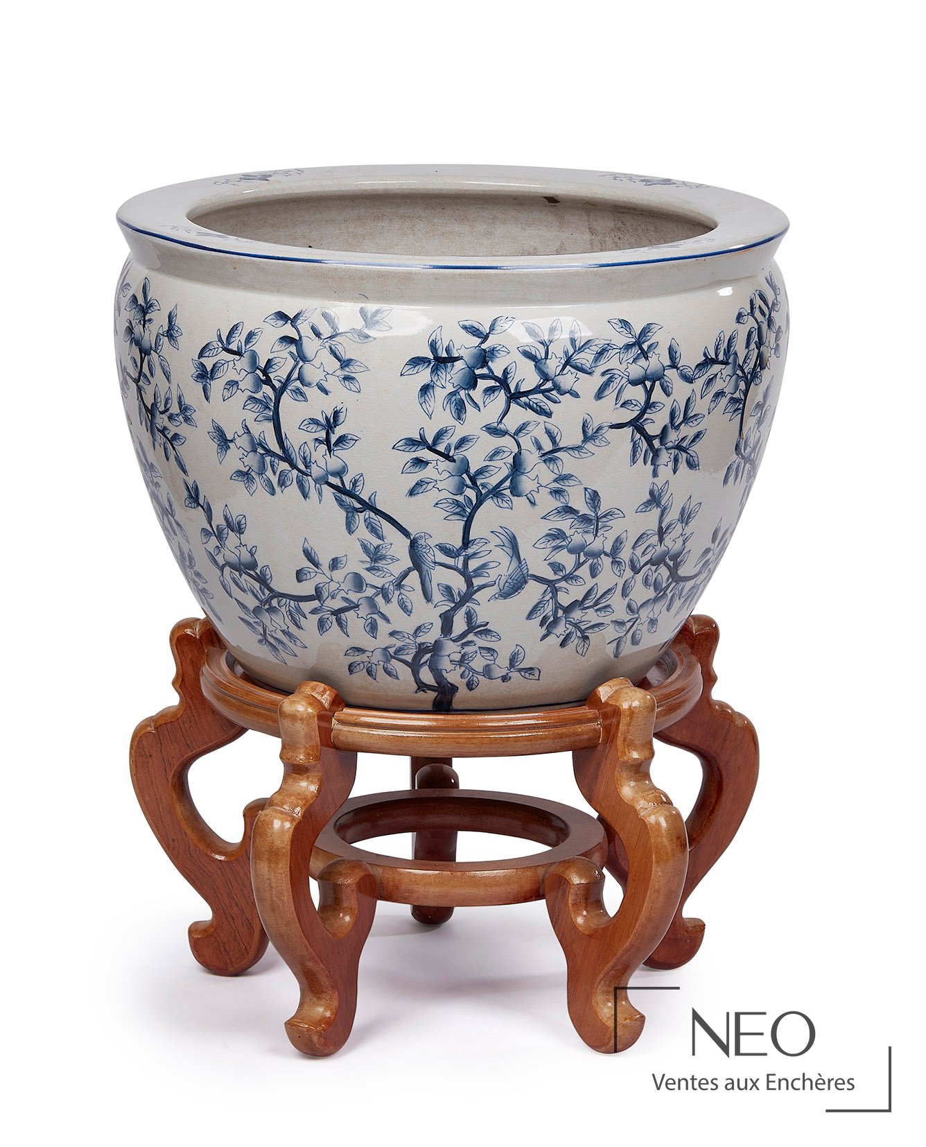 Grand vase en porcelaine bleue et blanche posé sur un socle en bois