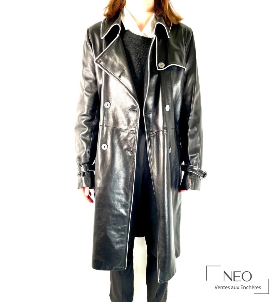 Manteau noir en cuir porté de face avec liseré blanc et boutons métalliques