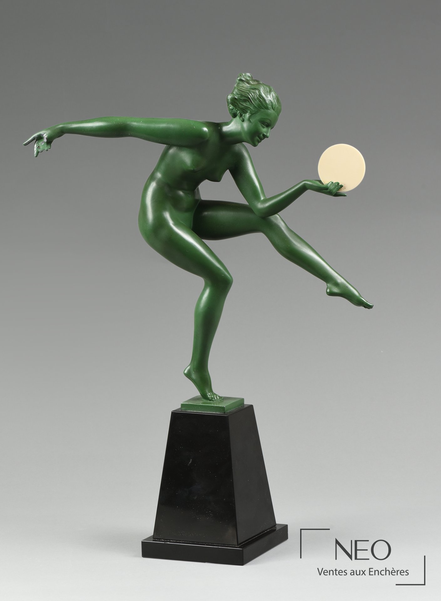 Danseuse Art Déco verte tenant un disque blanc