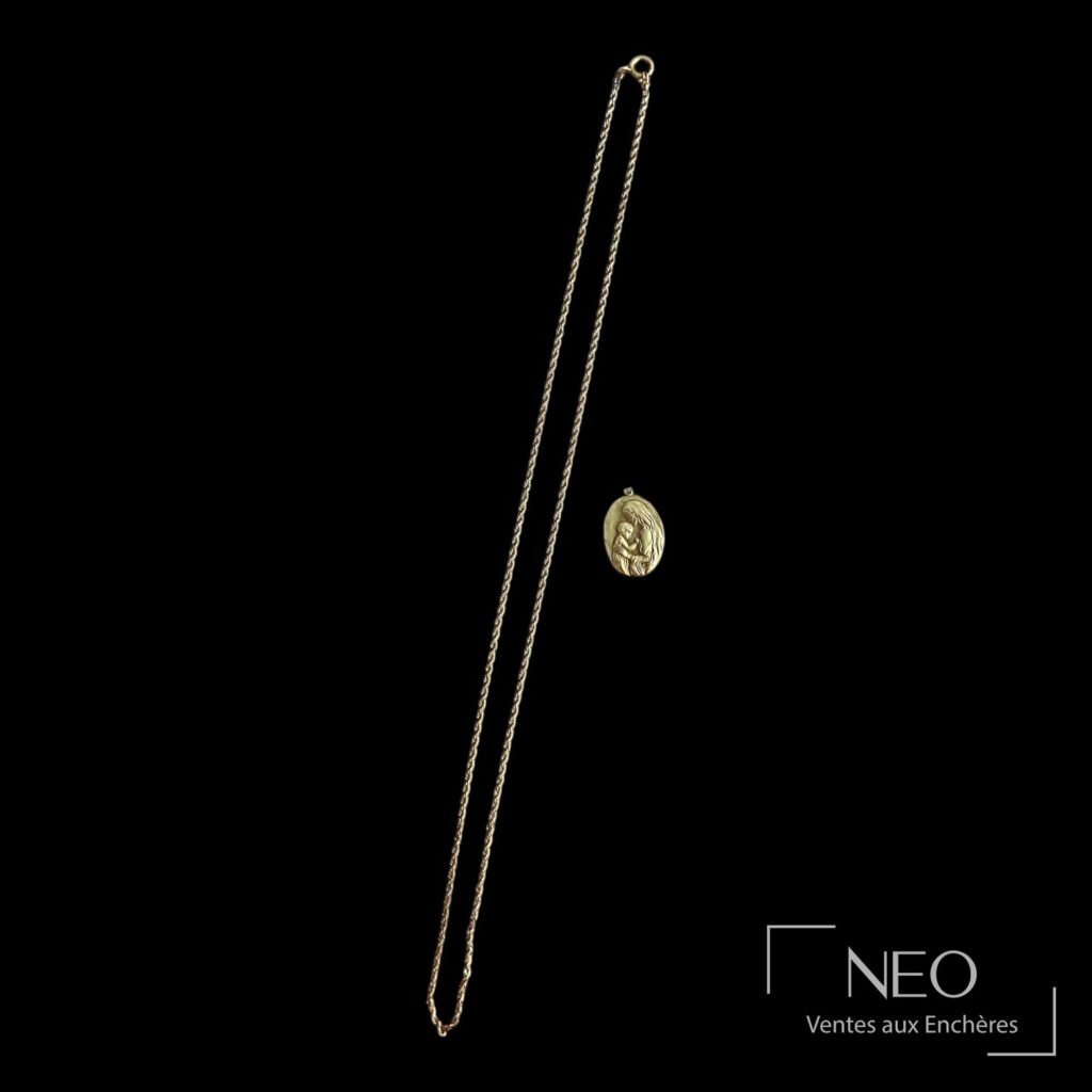 Médaille religieuse en or jaune avec chaîne torsadée sur fond noir