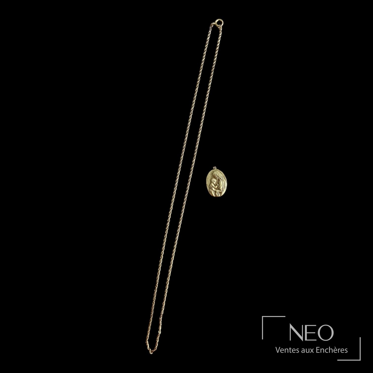Médaille religieuse en or jaune avec chaîne torsadée sur fond noir
