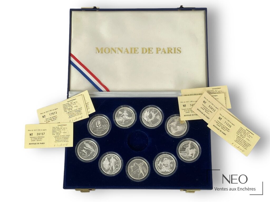 Coffret Monnaie de Paris ouvert avec neuf pièces en argent et plusieurs certificats.
