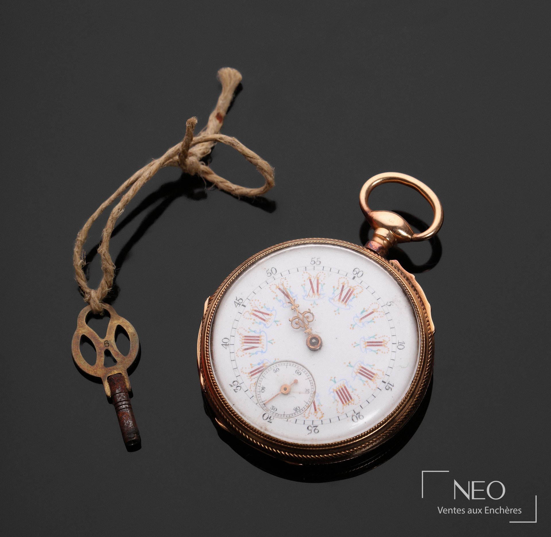 Montre à gousset en or rose avec cadran émaillé blanc et clé sur fond sombre