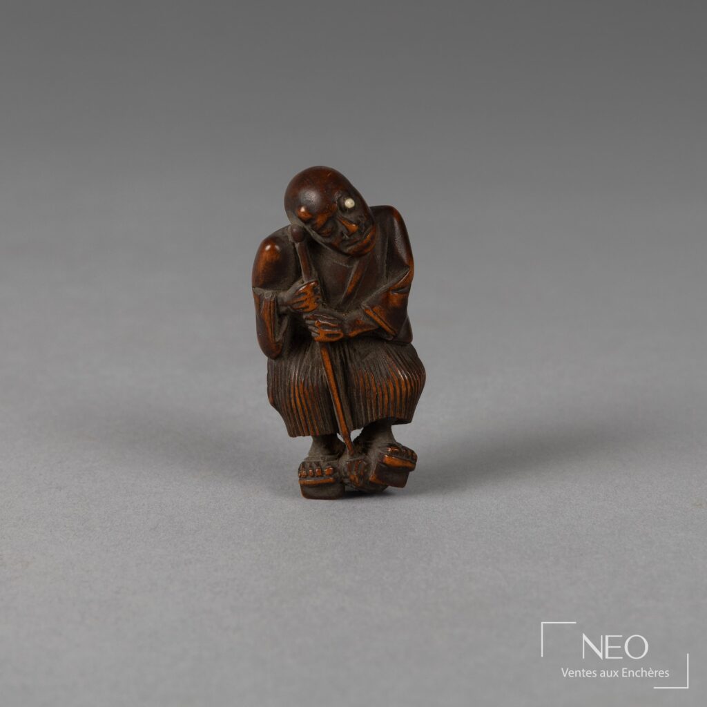 Netsuke japonais en buis représentant un aveugle debout appuyé sur son bâton