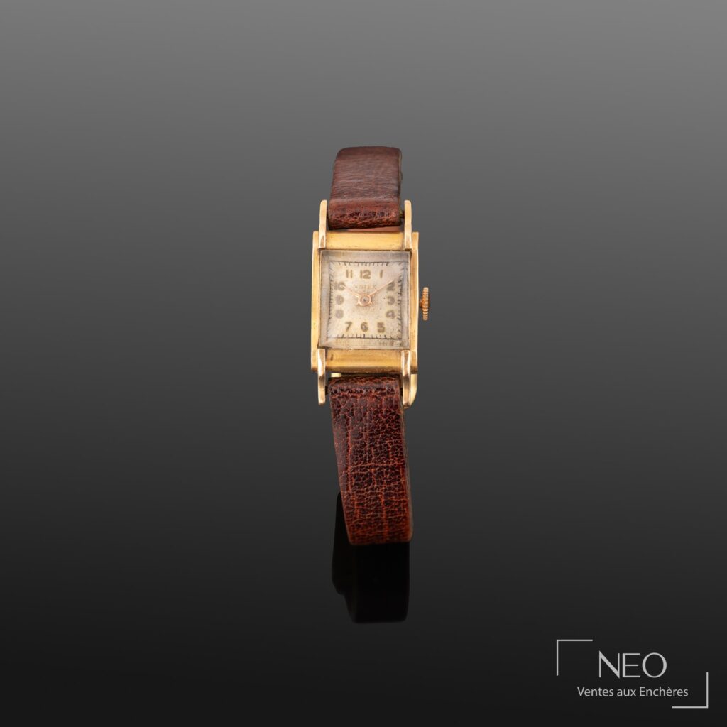 Montre rectangulaire à boîtier doré et bracelet brun vue de face