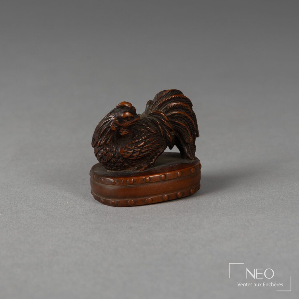 Netsuke en buis représentant un coq posé sur un tambour