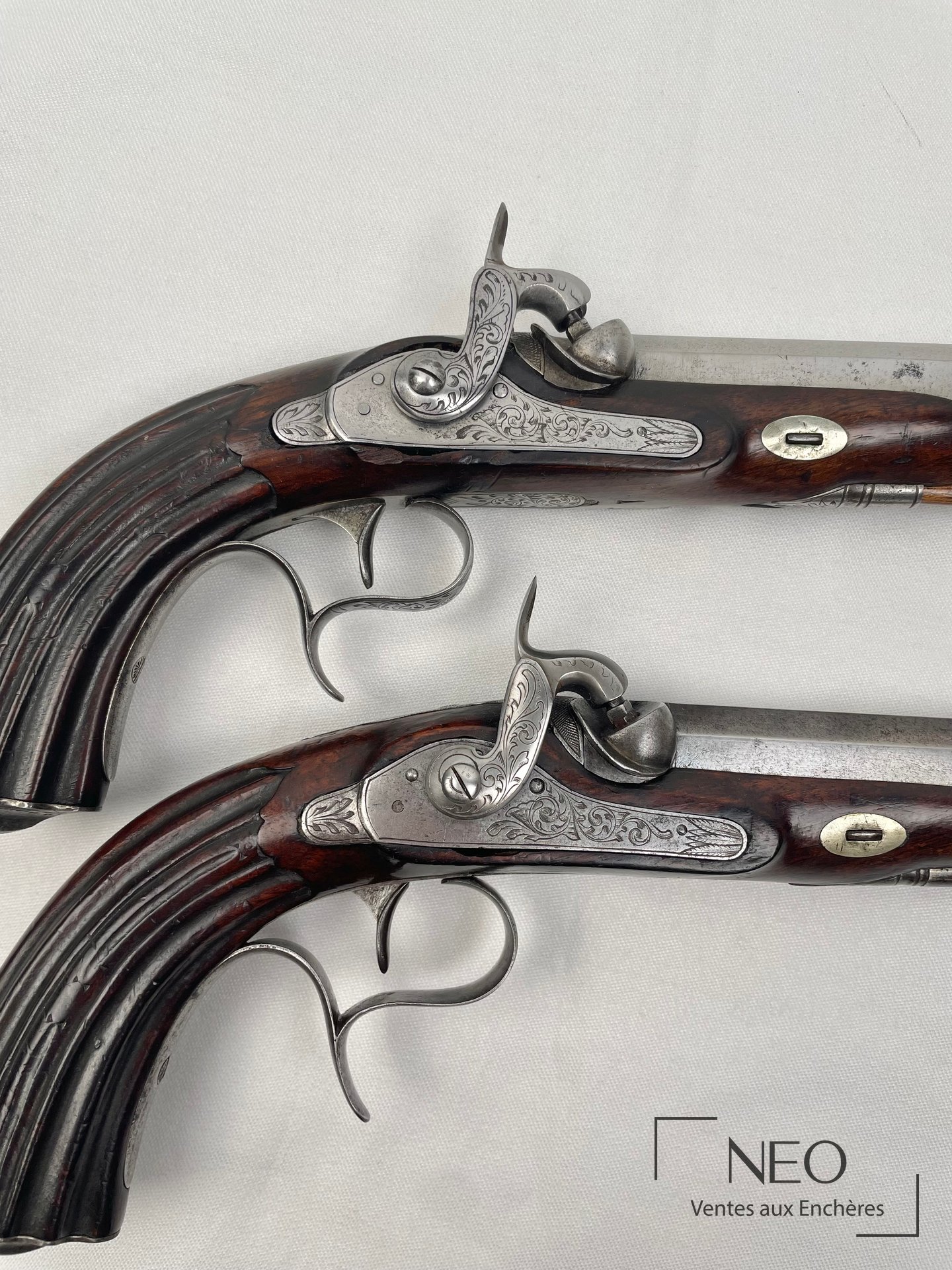 Paire de pistolets à percussion avec canons à pans et crosses en noyer sculpté