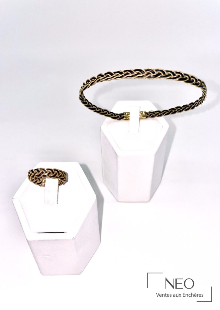 Parure avec bague tressée et bracelet en cuir marron sur supports blancs