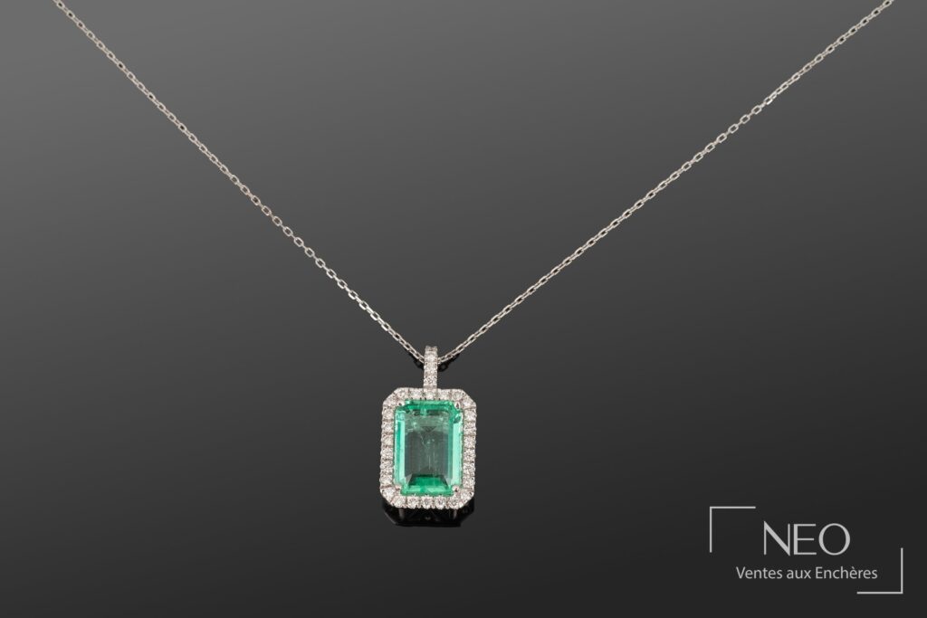 Pendentif en or blanc avec émeraude rectangulaire entourée de diamants