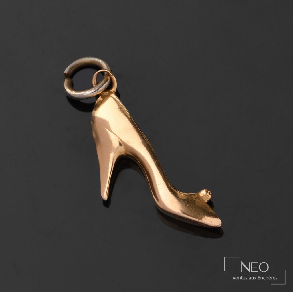 Pendentif en forme d'escarpin en or jaune sur fond noir