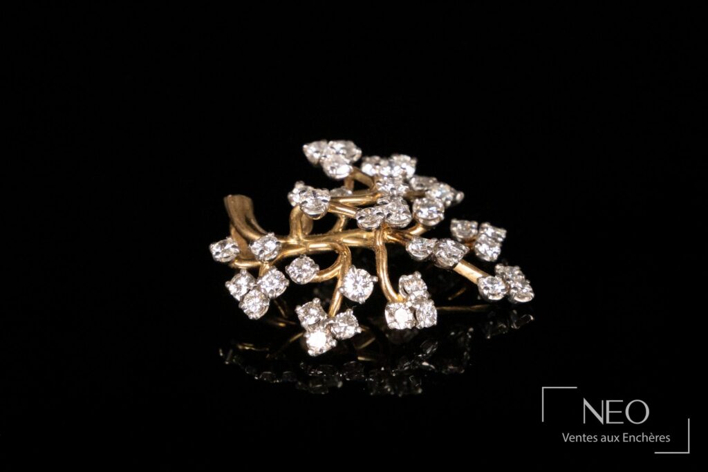 Pendentif feuillagé en or jaune serti de petits diamants sur fond noir