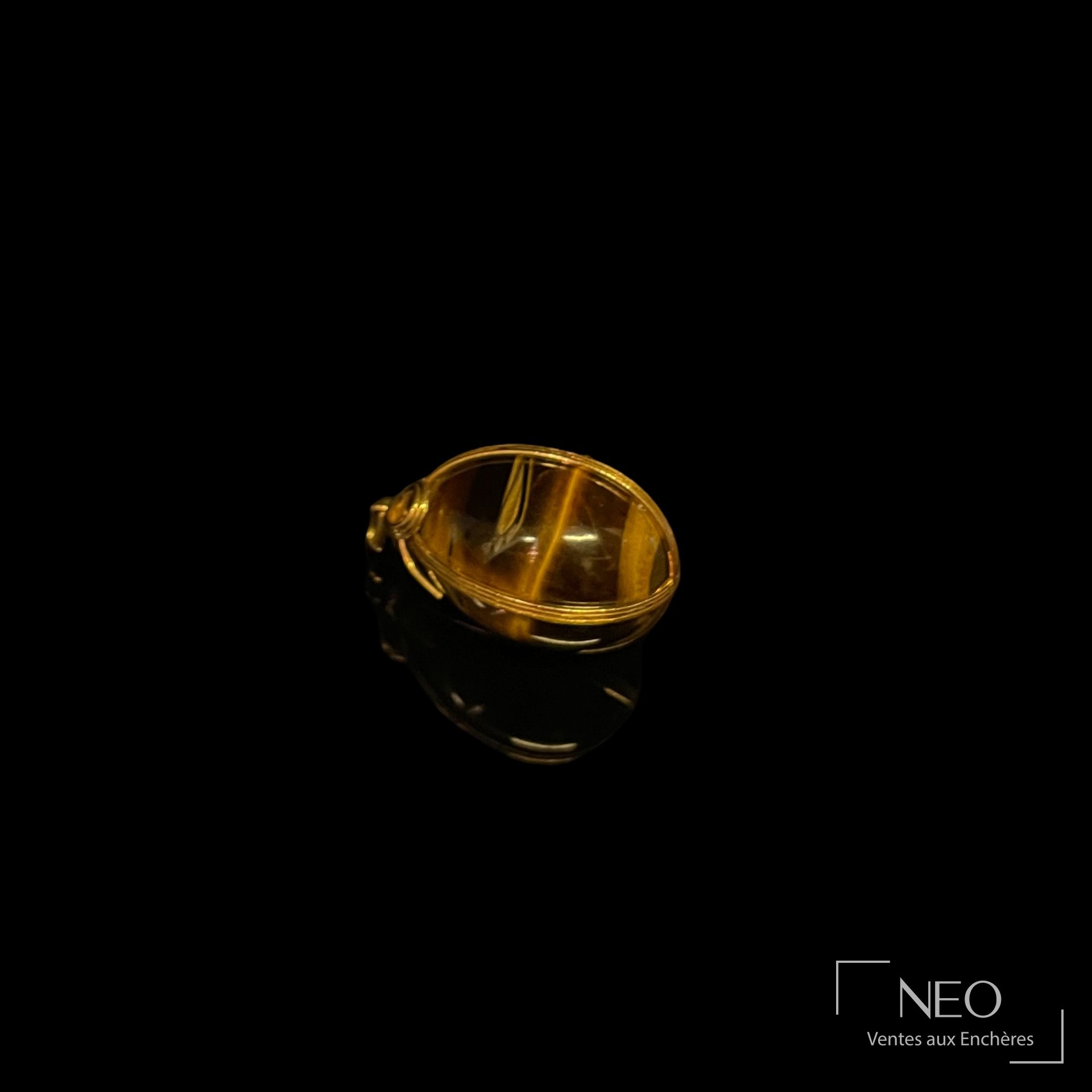 Pendentif œuf en œil de tigre monture de rubans et nœud en or jaune 18 carats