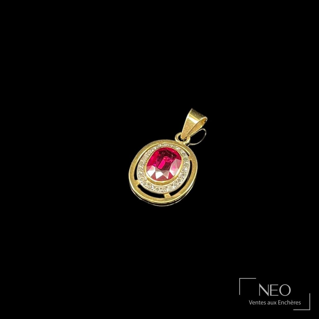 Pendentif en or jaune et platine avec pierre rouge ovale entourée de brisures de diamants
