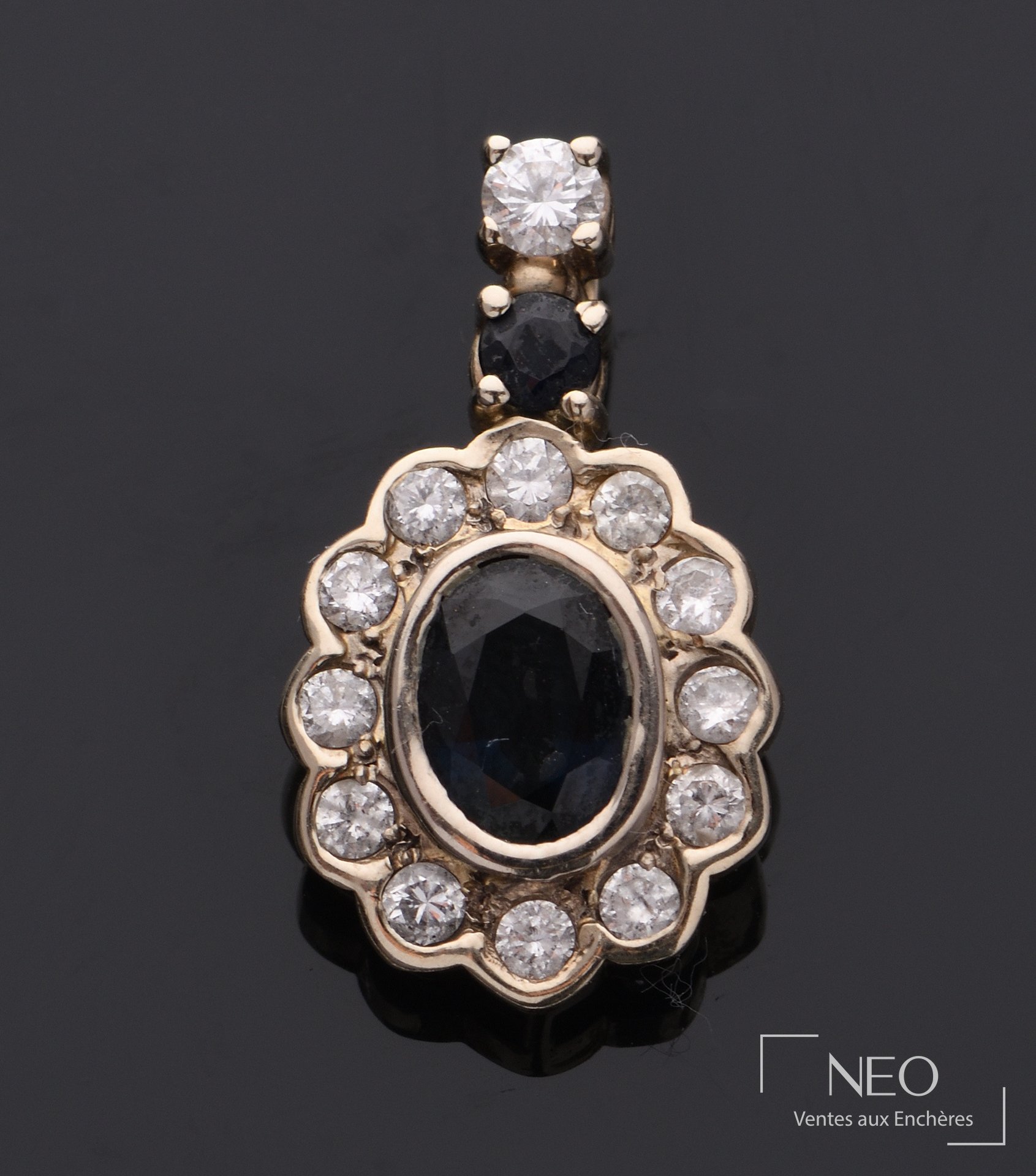Pendentif ovale en or gris 18 carats serti d’une pierre bleue et diamants