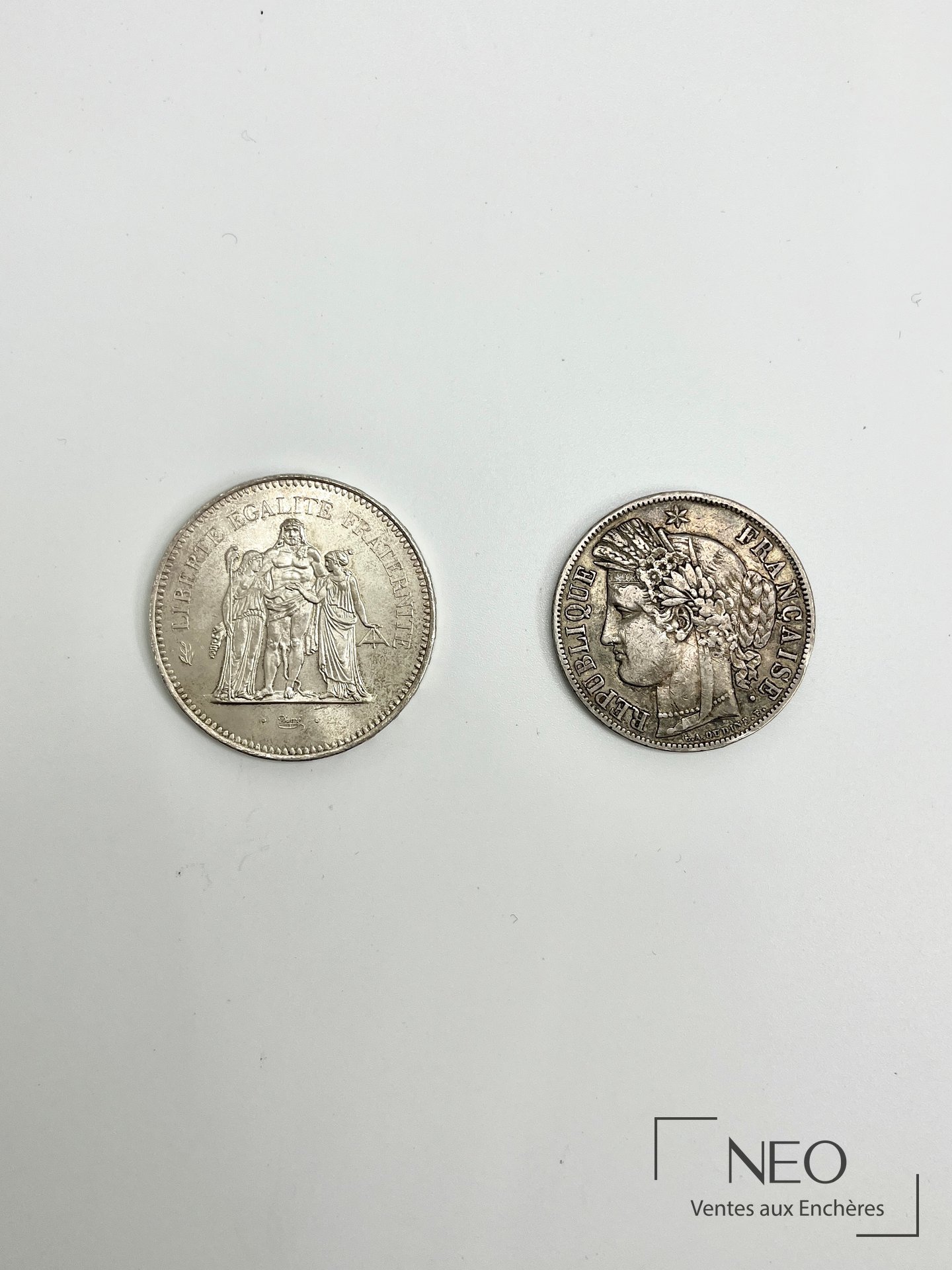 Deux pièces de monnaie en argent : 5 francs Cérès 1850 et 50 francs Hercule 1976