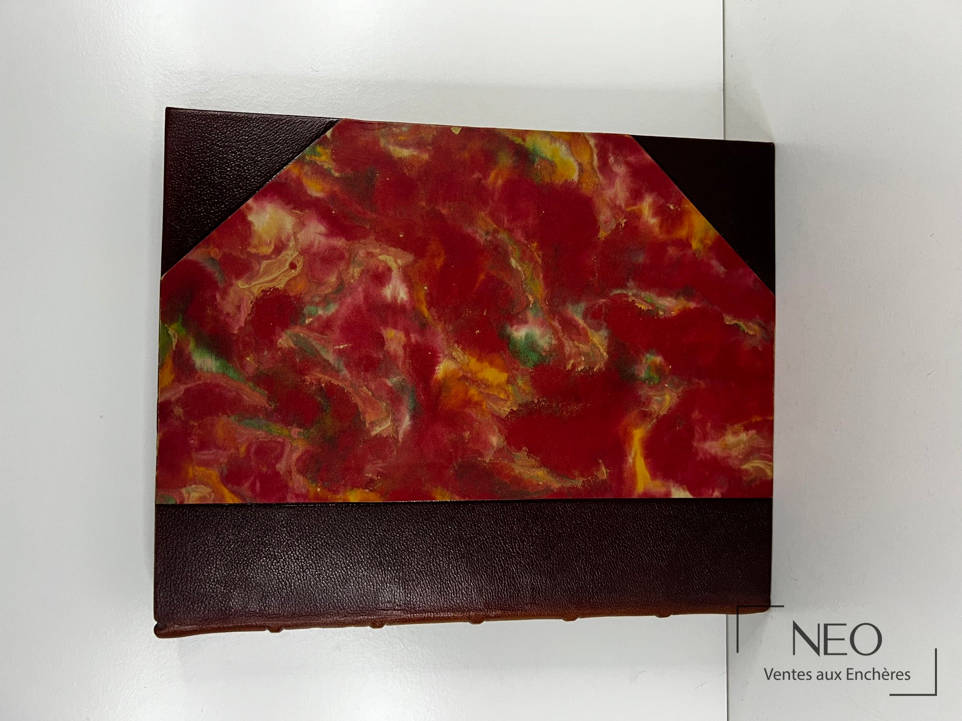 Couverture de l'ouvrage avec décor marbré rouge et reliure sombre.