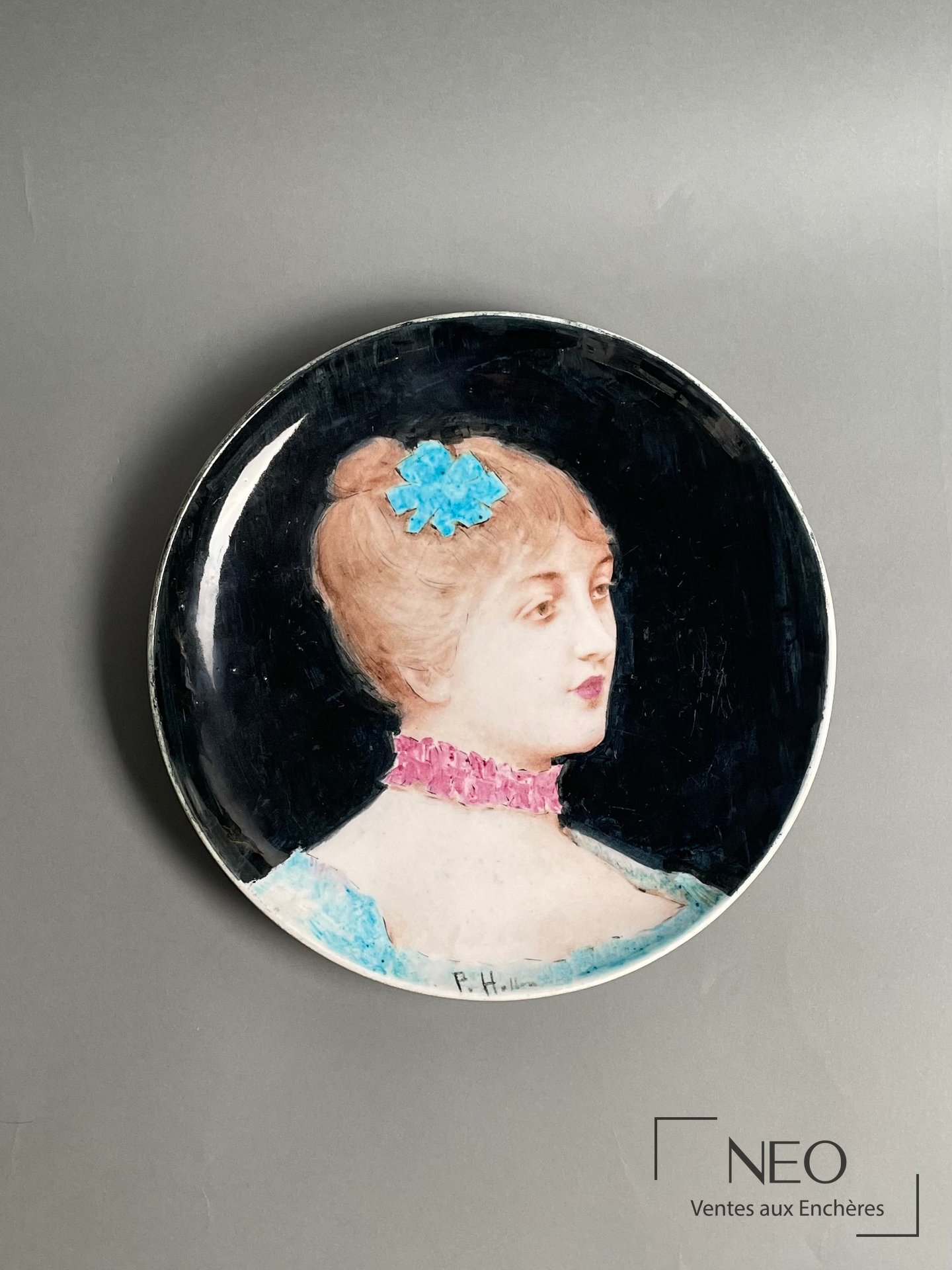 Plat circulaire en faïence montrant le portrait d'une jeune femme sur fond noir