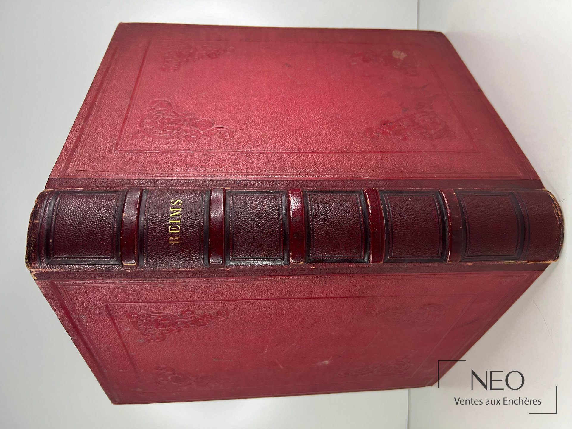 Reliure rouge d'un ouvrage ancien avec dos à nerfs et titre doré REIMS