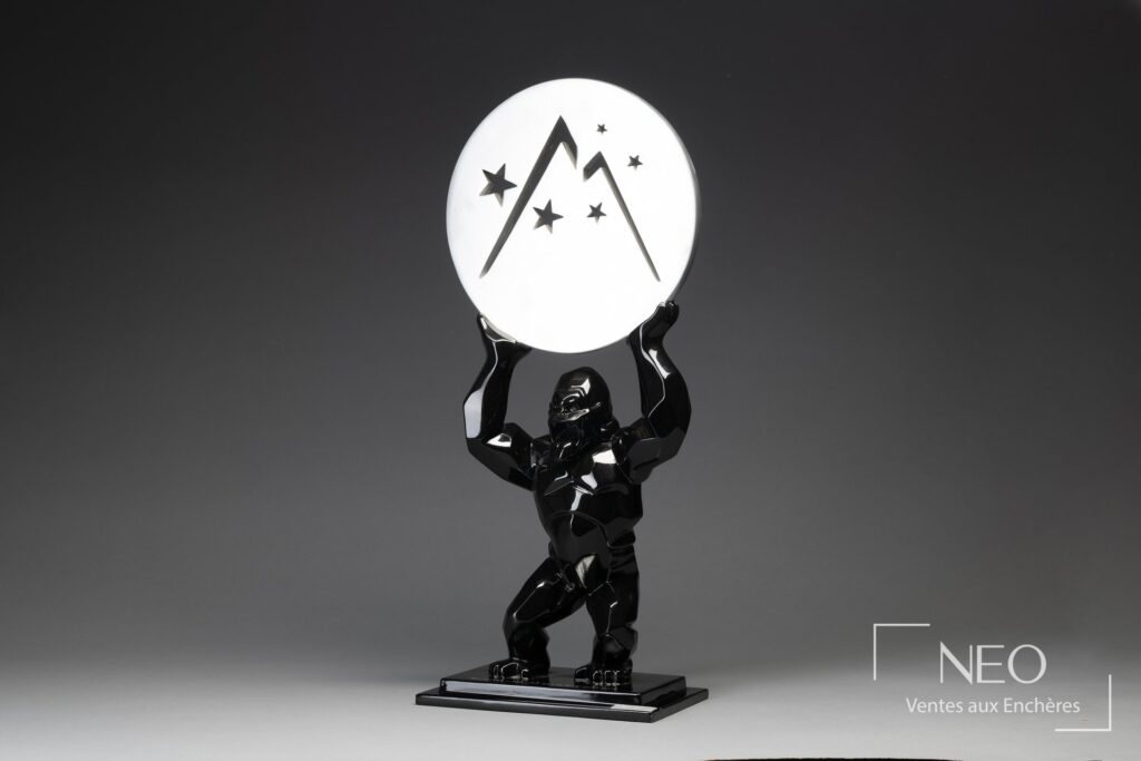 Sculpture Kong noire tenant un disque argenté décoré d'étoiles