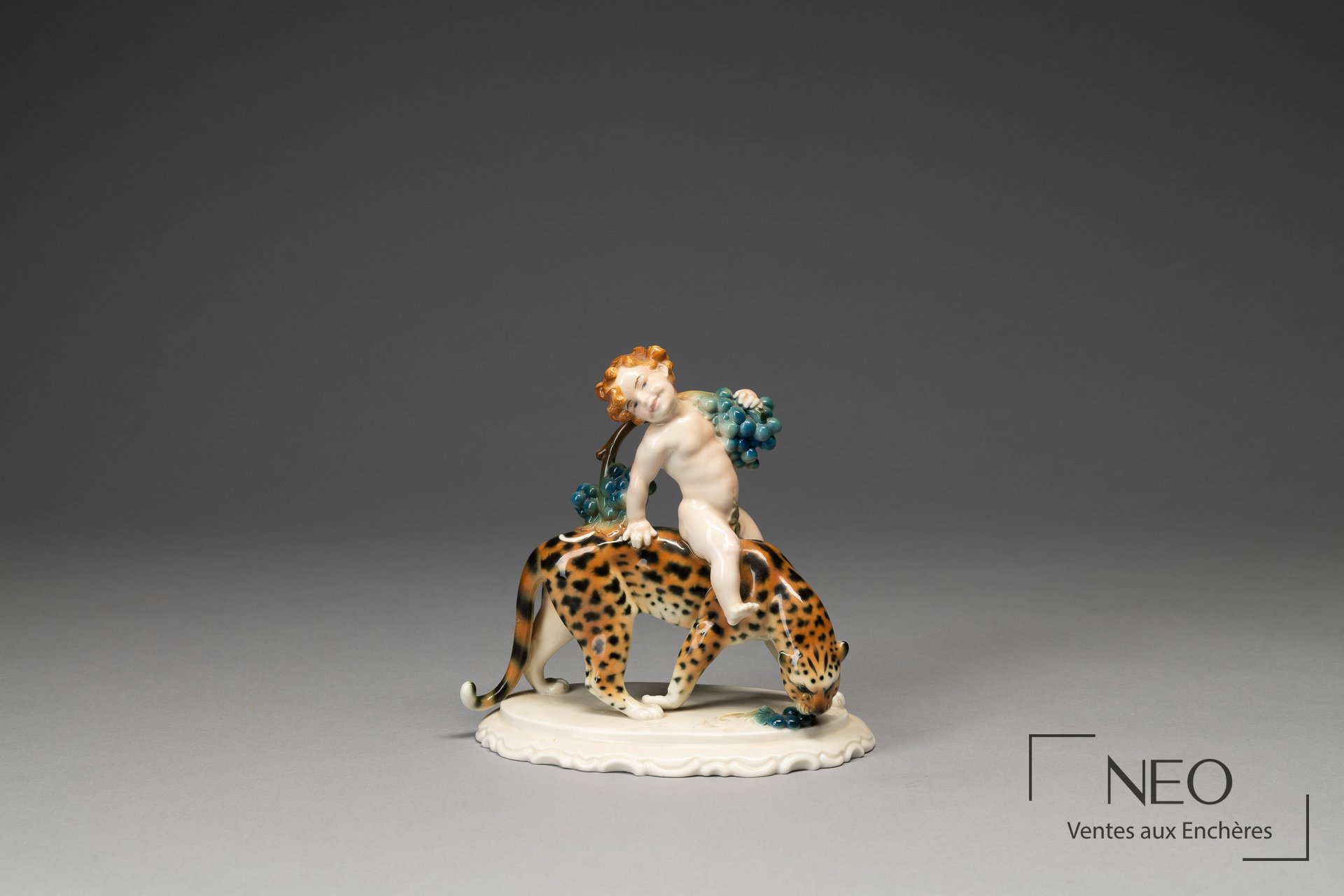 Jeune Bacchus en porcelaine polychrome sur un léopard