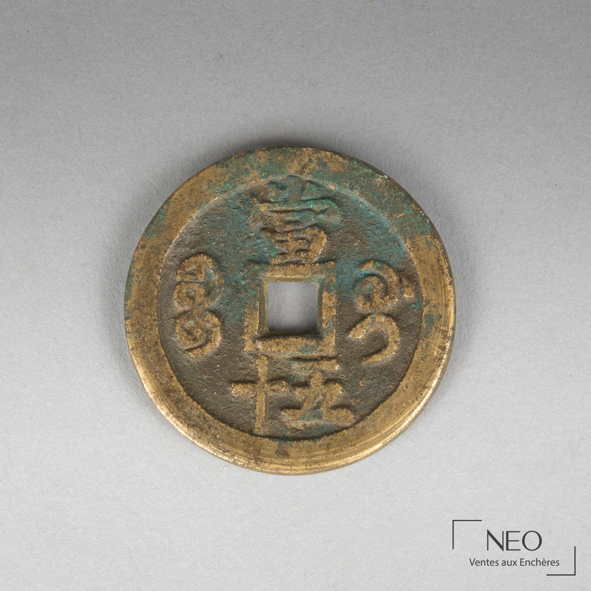 Sapèque chinoise en métal doré vue de face