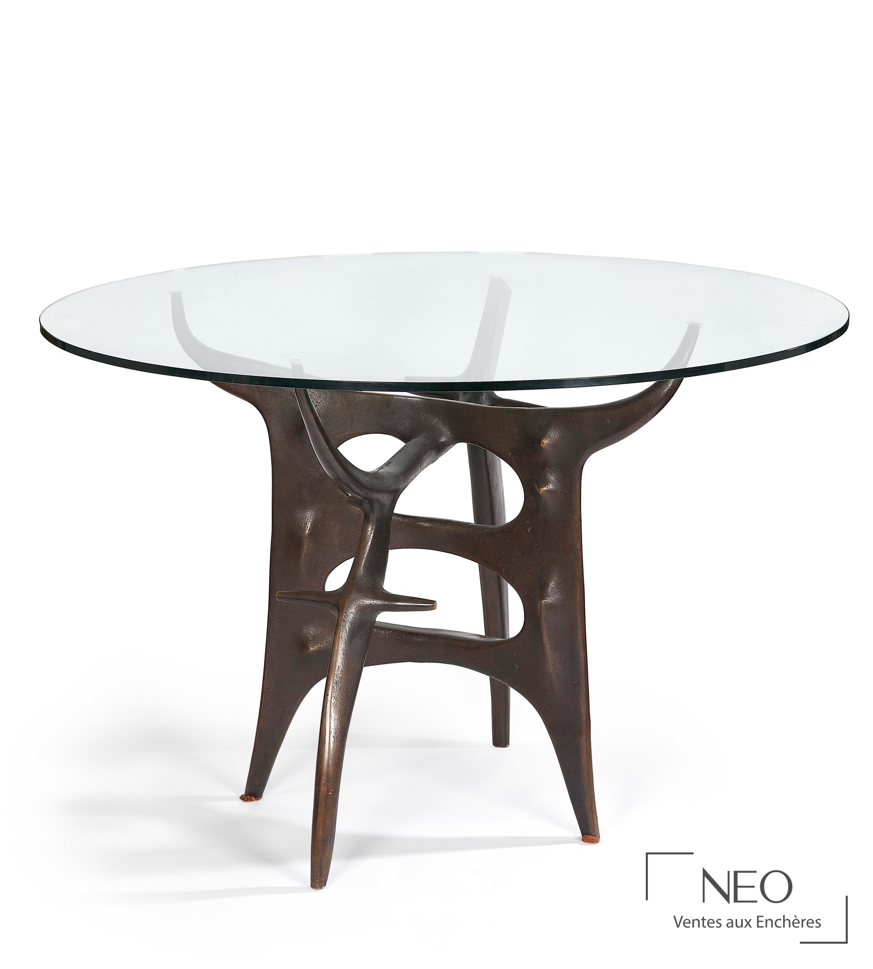 Table de salle à manger circulaire avec plateau en verre transparent et piètement en bronze patiné