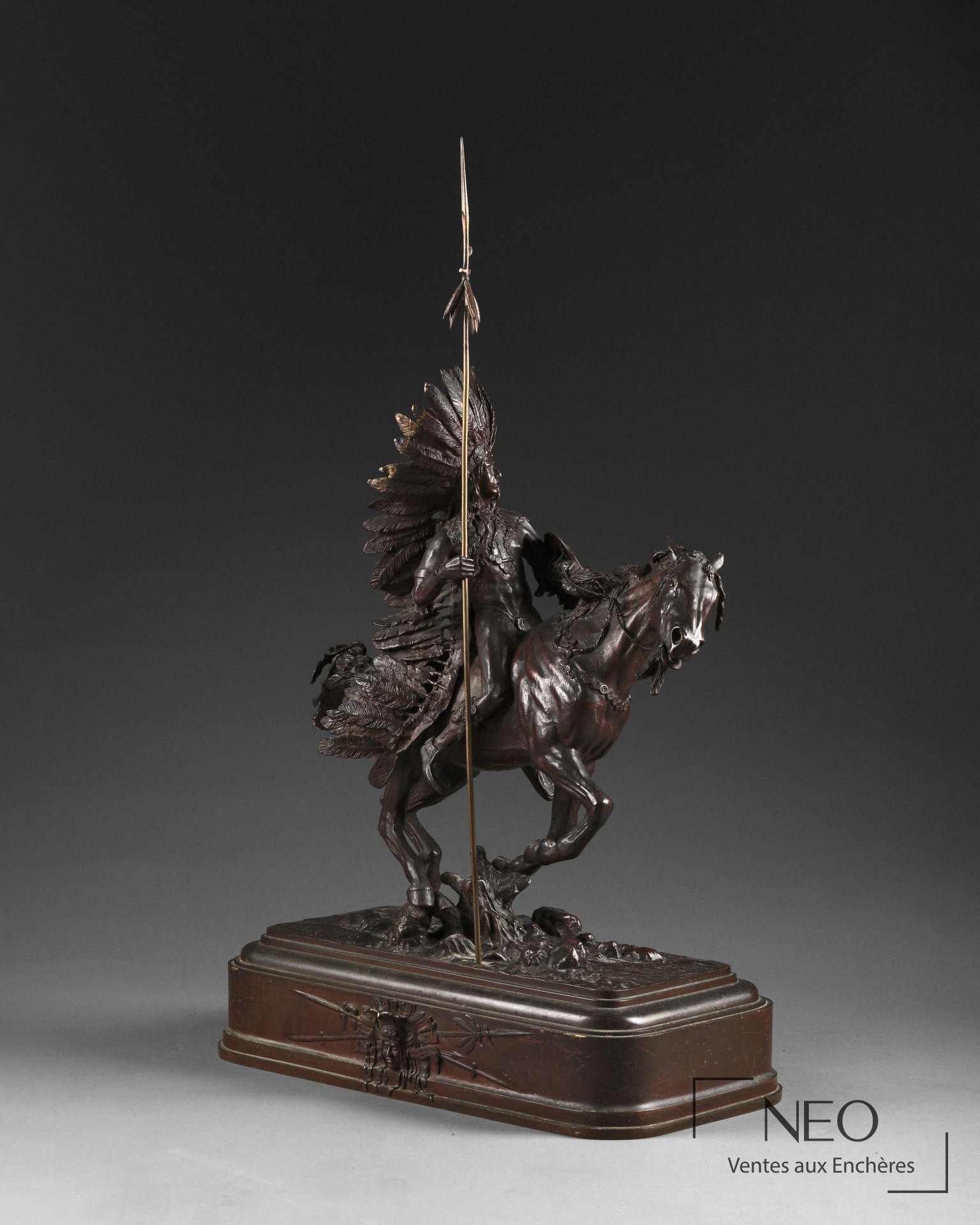 Sculpture en bronze représentant un chef indien sioux à cheval avec lance et coiffe de plumes.